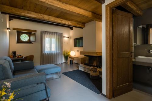 a living room with a blue couch and a fireplace at Borgotufi Albergo Diffuso in Castel del Giudice