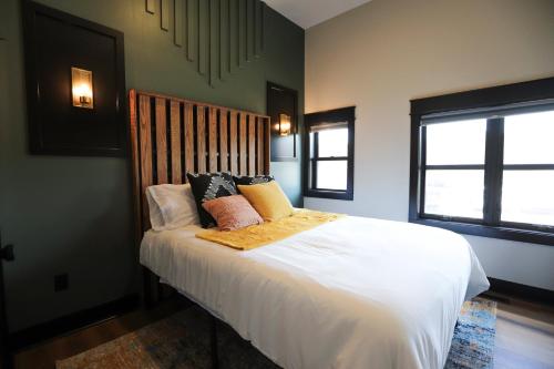 a bedroom with a bed with white sheets and pillows at Chic Queen Apartment At The Victorian Unit A in Muskegon