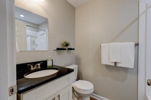 a bathroom with a sink and a toilet and a mirror at Mimosa Getaway - Thomasville Fun! in Thomasville