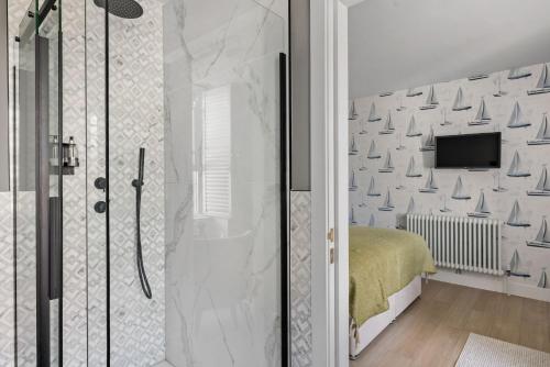 a bathroom with a shower and a bed and a television at Leader Suite - Sea View - Free Wi-Fi in Brixham
