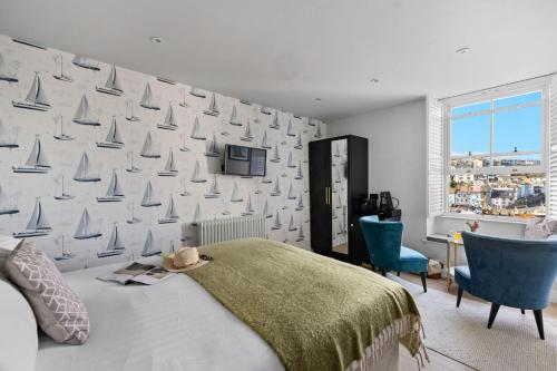 a bedroom with a bed and a wall with sailboats at Leader Suite - Sea View - Free Wi-Fi in Brixham