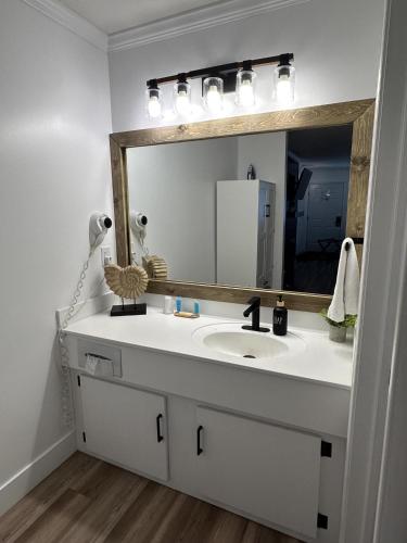 a bathroom with a white sink and a mirror at Legends Fountain View Ground Floor Studio Unit 109 in Bellaire