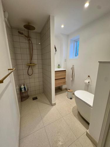 a bathroom with a tub and a toilet and a sink at Cozy and Spacious Guest Room, Virum in Virum