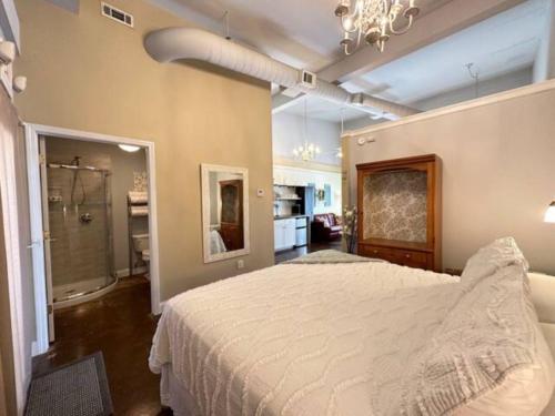 a bedroom with a large bed and a bathroom at Haven at Hazel~Downtown Bungalow in Demorest