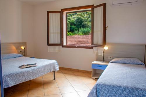 a room with two beds and a window at Residence Villa Franca in Capoliveri