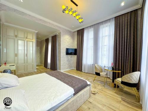 a bedroom with a bed and a table and chairs at River Hotel Restaurant in Quba