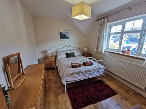 a bedroom with a bed and a window at Unbeatable Llanberis Location, Detached with Parking, Snowdon Views. in Llanberis