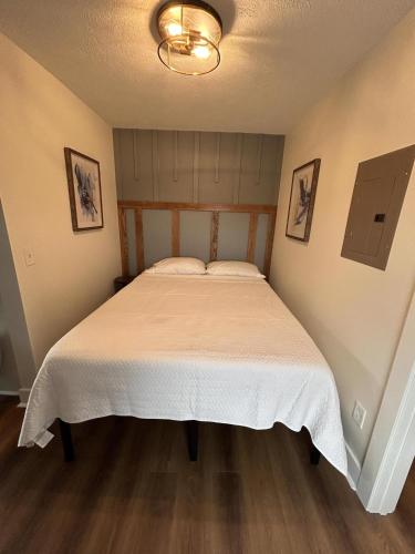 a bedroom with a bed with a white bedspread at Victorian Queen Getaway Unit C Washerdryer in Muskegon