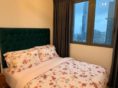 a bedroom with a bed with a green headboard and a window at Tri-Zen Luxury Apartment Colombo, Tower 02, 20F, A2 in Colombo