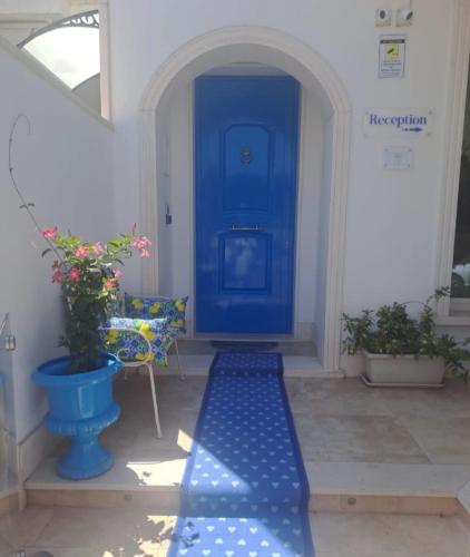 a blue door with a bench in front of it at Falli Exclusive Rooms and Breakfast -Boutique B&B- in Porto Cesareo