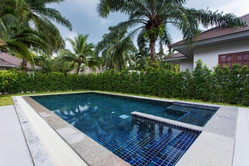 a swimming pool with blue tiles in front of a house at Alisea Pool Villa Aonang in Ao Nang Beach