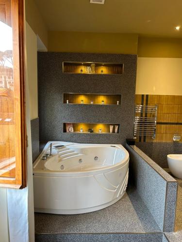 a large white tub in a bathroom with a sink at Residenza Leone XIII in Rome