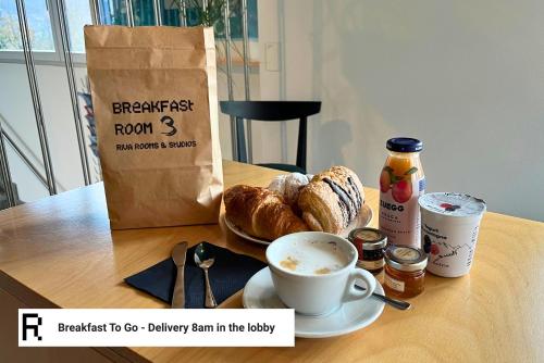 a table with a bag of bread and a cup of coffee at Riva Rooms & Studios - Check-In 24hr in Locarno