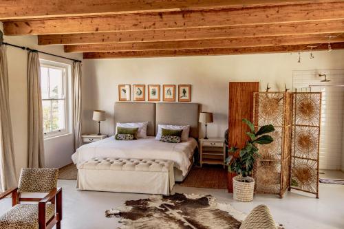 a bedroom with a large bed and a wooden ceiling at Firgrove Country Lodge in Robertson