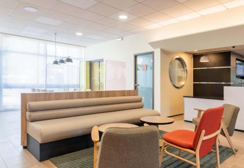 a waiting room with chairs and a table at B&B HOTEL Lyon Nord 4 étoiles in Dardilly