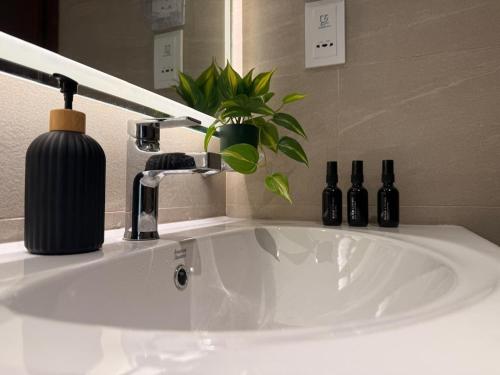 a bathroom sink with a black soap dispenser on it at Tri-Zen Luxury Apartment Colombo, Tower 02, 20F, A2 in Colombo