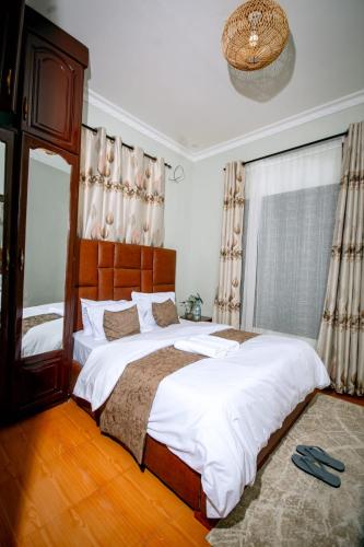 a bedroom with a large bed and a large window at Lasai casa in Arusha