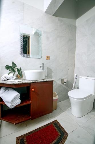 a bathroom with a sink and a toilet and a mirror at Lasai casa in Arusha