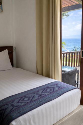 a bedroom with a bed and a view of the ocean at The Pade Dive Resort in Sabang