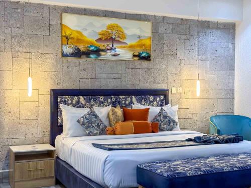 a bedroom with a large bed with orange pillows at Blue Orange Hotel and Towers in Shomolu