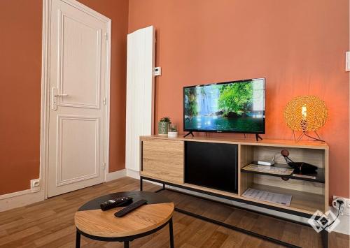 a living room with a flat screen tv on a entertainment center at Le Bailly charmant T2 Confort calme hyper centre in Orléans