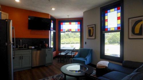 a living room with a blue couch and stained glass windows at Modern Queen Apartment At The Victorian Unit E in Muskegon