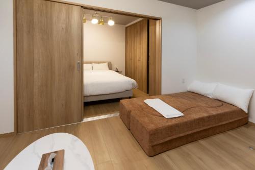 a bedroom with a bed and a mirror at Bio Top Apartment Stay in Fukuoka