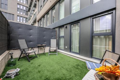 a rooftop patio with grass and chairs on a building at Fancy Studio with Terrace & Pool - Madrid South in Villaverde