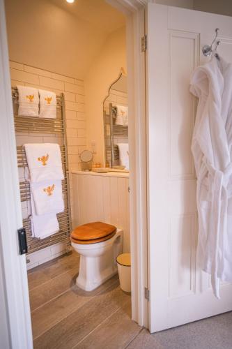 a bathroom with a toilet with a wooden toilet seat at Challens Yarde in Midhurst