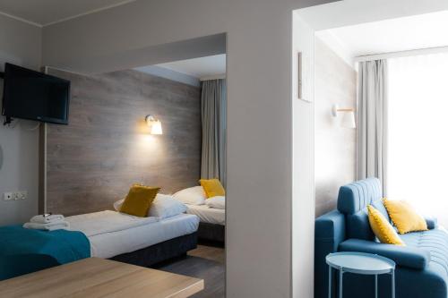 a hotel room with two beds and a blue chair at Villa Flaming in Sopot