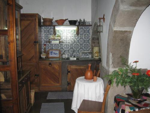 uma cozinha com uma mesa com um vaso sobre ela em Quinta do Rossio, Rural Tourism em Biscoitos