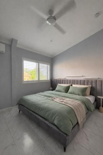 a bedroom with a large bed with a ceiling fan at The Green Shouse in Stanthorpe