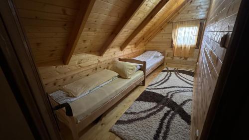 a room with two beds in a log cabin at Koliba Bajka in Bijelo Polje