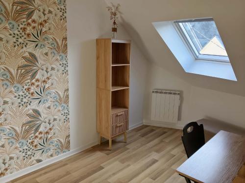 an attic room with a book shelf and a window at Au 24 a connerre in Connerré