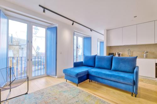 a blue couch in a living room with windows at InLoveApartments - Luxury in Alfama in Lisbon