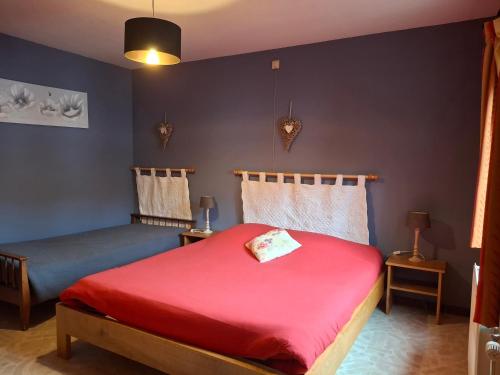 una camera da letto con un letto rosso e una parete blu di Villa Clara a La-Roche-en-Ardenne