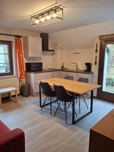 una cucina e una sala da pranzo con tavolo e sedie di Villa Clara a La-Roche-en-Ardenne