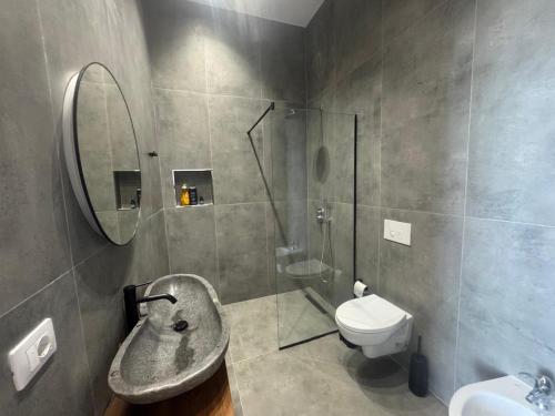 a bathroom with a sink and a shower and a toilet at Elite Sunset Residence in Vlorë