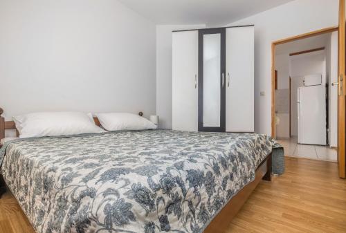 a bedroom with a bed with a blue and white blanket at Sweet Escape in Makarska