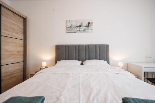 a bedroom with a large white bed with two chairs at MaxInn 14 in Pirot