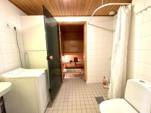 a bathroom with a shower and a toilet and a sink at Warm and cozy one-bedroom & Sauna in Vantaa