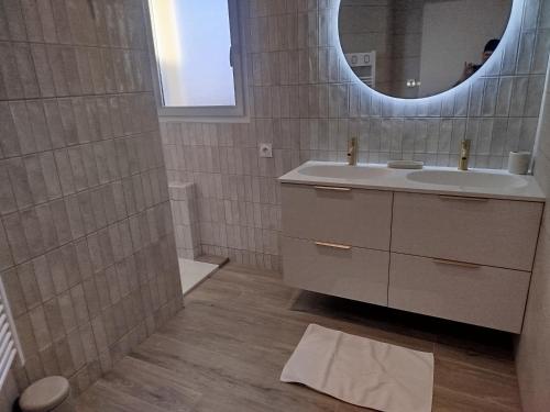 Chambre d'hôtes Tout Simplement في Beaurepaire: حمام مزود بحوض ومِرآة