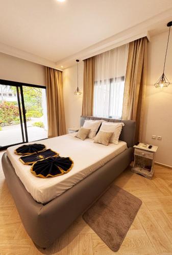 a large bed in a bedroom with a large window at Victory Hotel & Restaurant Tulear in Toliara