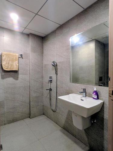a bathroom with a sink and a shower with a mirror at Home Bliss BnB in Greater Noida