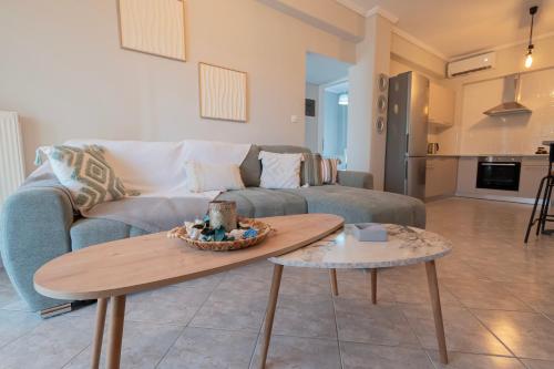 a living room with a couch and a table at Aeris Apartment by Booking Kottas in Nea Moudania
