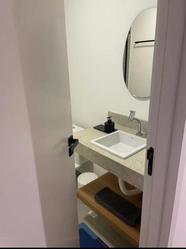a bathroom with a sink and a mirror at Cozy Moov Smart Apartamento in Cuiabá