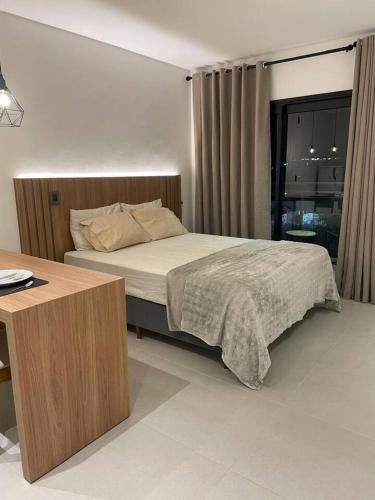 a bedroom with a bed and a desk in it at Cozy Moov Smart Apartamento in Cuiabá