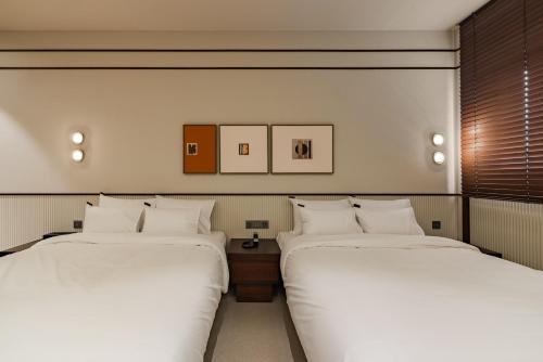two beds sitting next to each other in a room at Mansion Bridge Cheonan in Cheonan