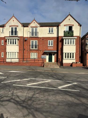 an empty parking lot in front of a large brick building at Two Bedrooms Two Bathrooms and Private Parking Rugby in Rugby