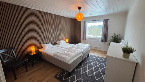 a bedroom with a bed and a table and a window at Lagom huset in Årjäng